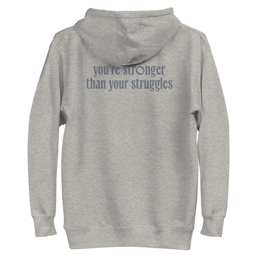 Back view of the gray sweater with the text 'you're stronger than your struggles' printed on it, promoting strength.